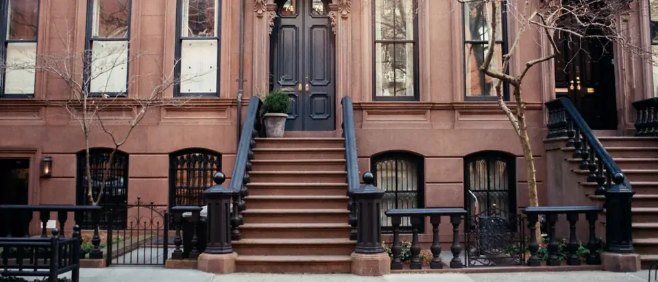 A New York brownstone with a high stoop and a garden-level entrance under it