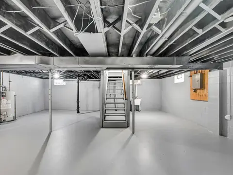 A cleared, dry basement with a concrete floor and open stairs