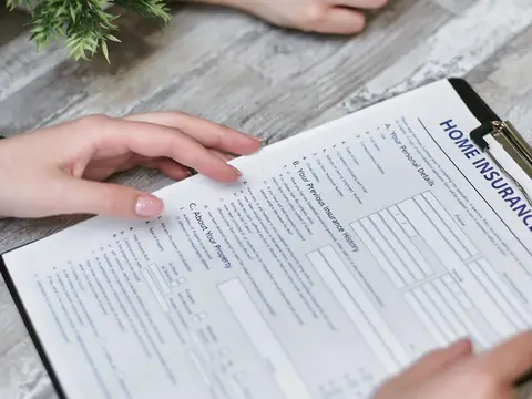 Hands holding a home insurance form on a clipboard