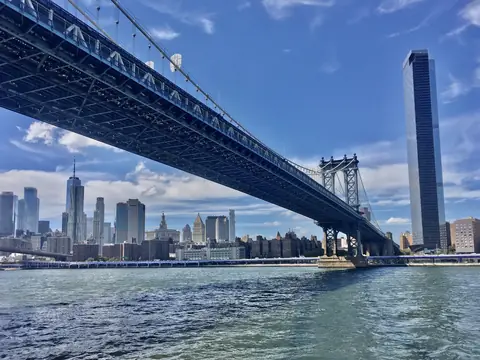 Lower Manhattan's skyline across the East River under the Manhattan Bridge